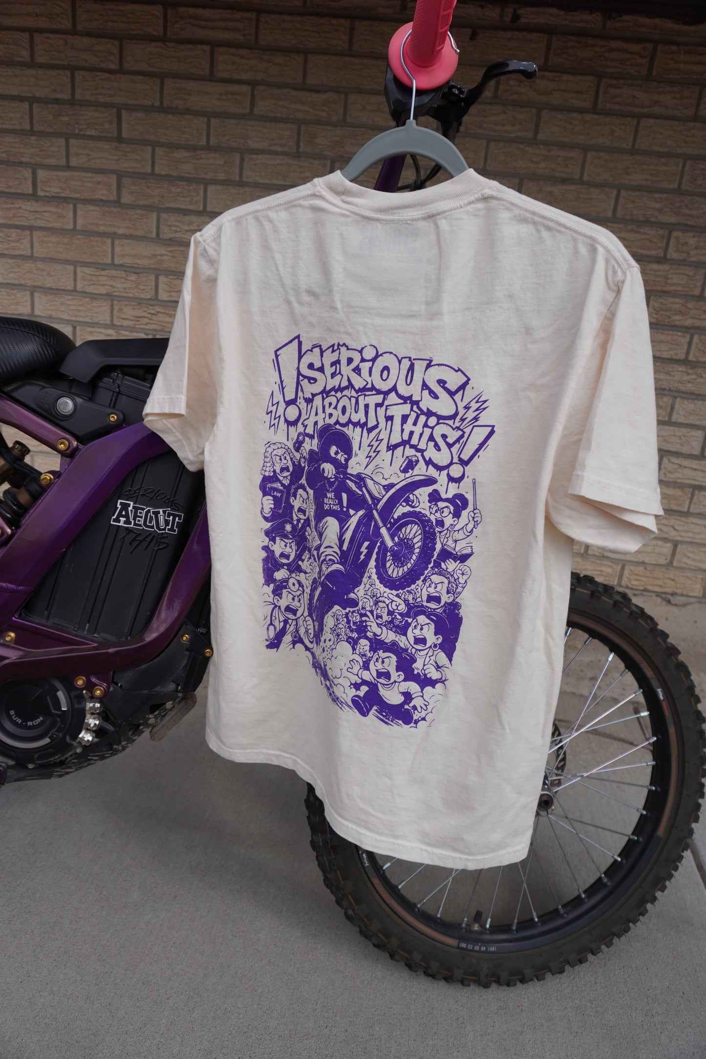 “Riding Regardless” - tan and purple t shirt